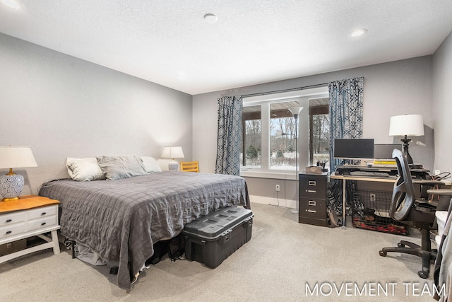 bedroom with a textured ceiling and light colored carpet