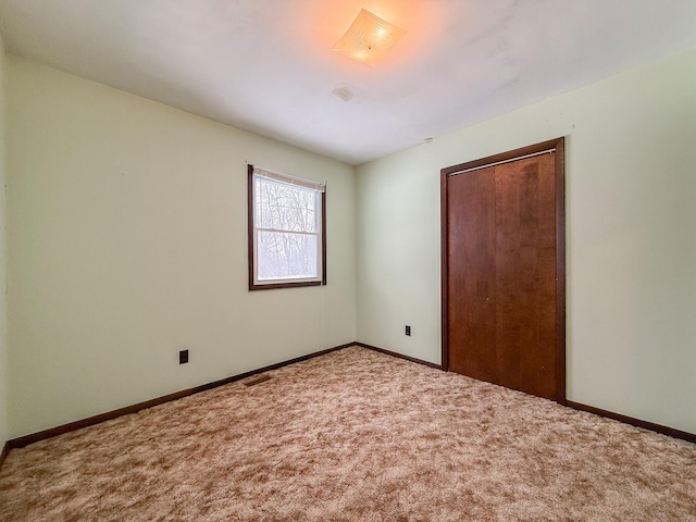 unfurnished bedroom with carpet floors and a closet