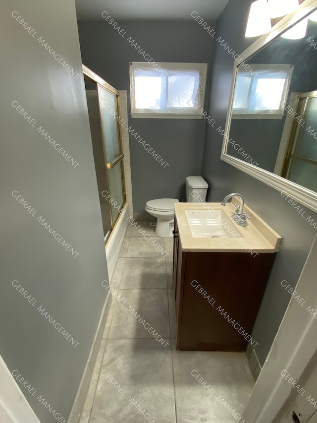 full bathroom with toilet, tile patterned flooring, vanity, and combined bath / shower with glass door