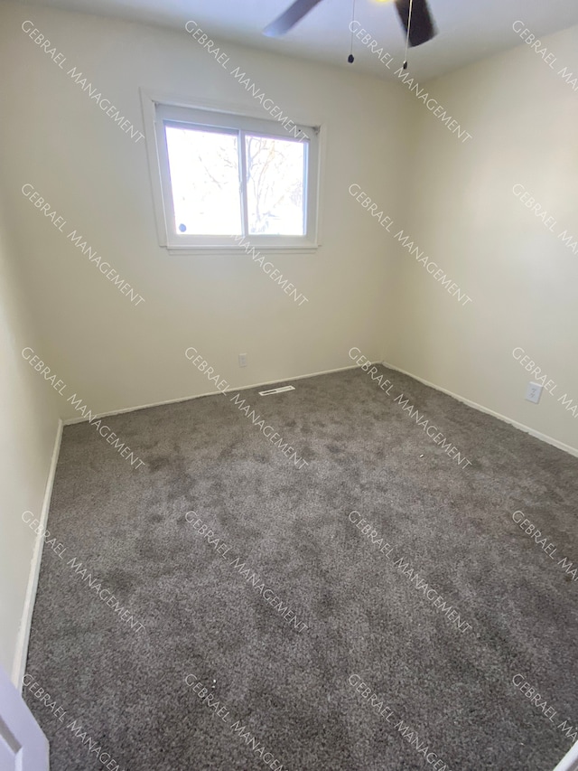 empty room with ceiling fan and dark carpet