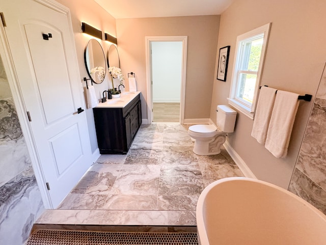 bathroom featuring vanity, a tub to relax in, and toilet