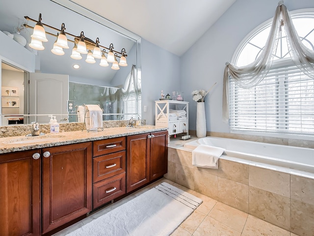 bathroom with tile patterned floors, vaulted ceiling, vanity, and shower with separate bathtub