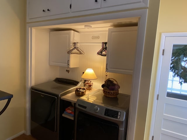 clothes washing area with cabinets and separate washer and dryer