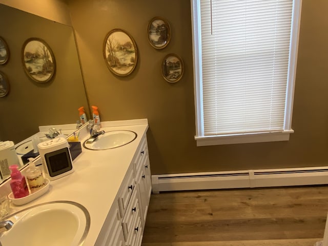 bathroom with vanity, a baseboard radiator, and wood-type flooring