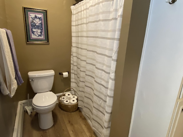 bathroom featuring hardwood / wood-style floors, toilet, and a baseboard heating unit