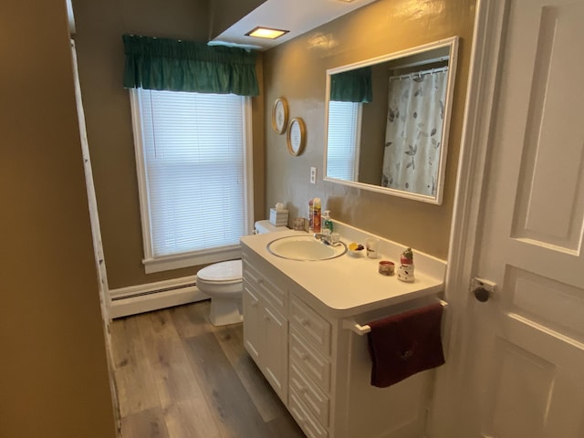 bathroom featuring walk in shower, vanity, a baseboard radiator, hardwood / wood-style floors, and toilet