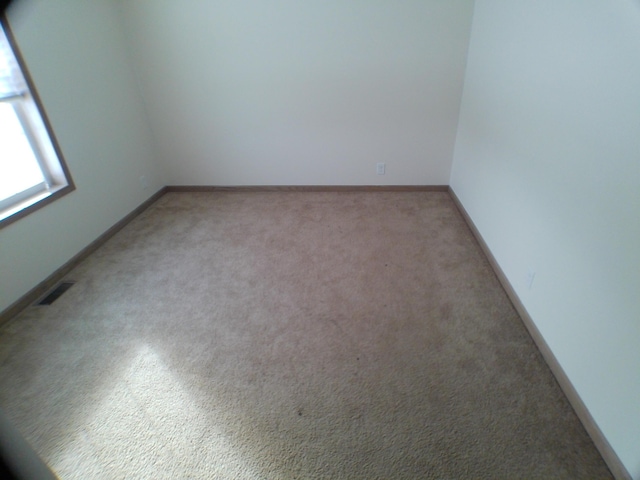 empty room featuring visible vents and baseboards