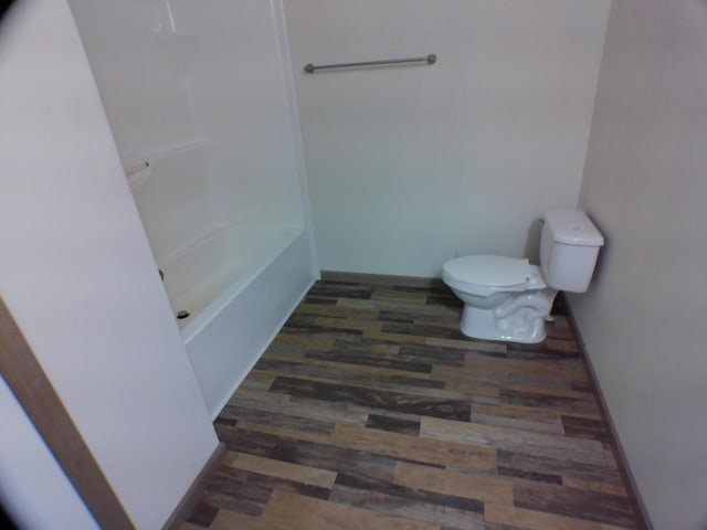 bathroom featuring wood finished floors, toilet, and baseboards