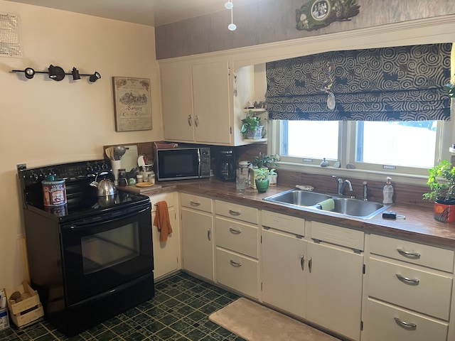 kitchen with sink, white cabinetry, and black appliances