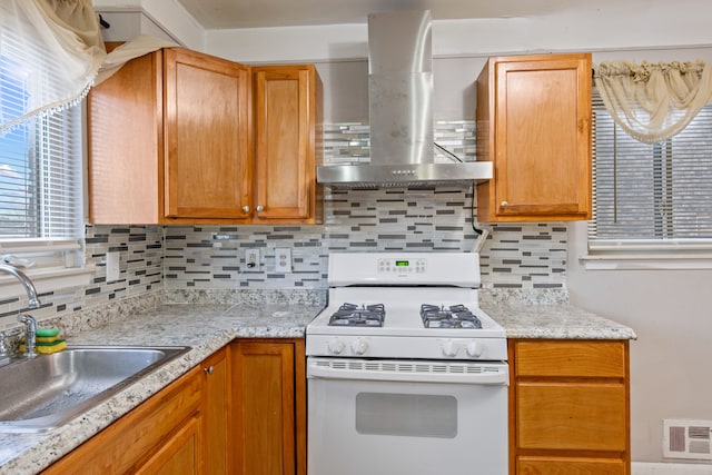 kitchen with decorative backsplash, wall chimney exhaust hood, sink, and white gas range