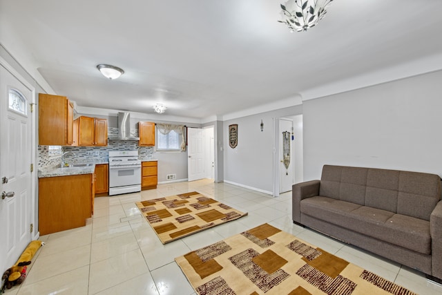 kitchen with backsplash, light tile patterned flooring, white gas stove, wall chimney range hood, and sink