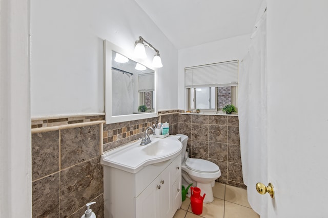 bathroom with tile walls, tile patterned floors, vanity, and toilet