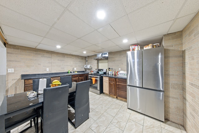 kitchen with sink, a paneled ceiling, and stainless steel appliances