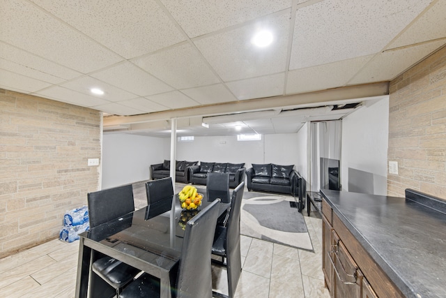 tiled dining room featuring a drop ceiling