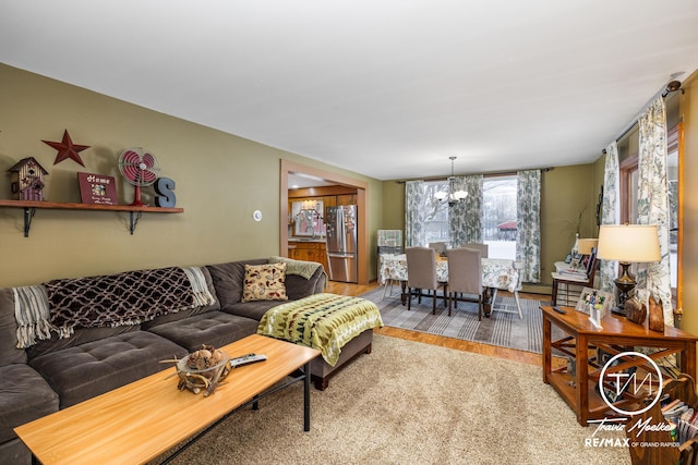 living room featuring hardwood / wood-style flooring, sink, and an inviting chandelier