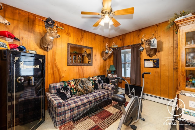 living room with ceiling fan, carpet floors, wooden walls, and a baseboard heating unit