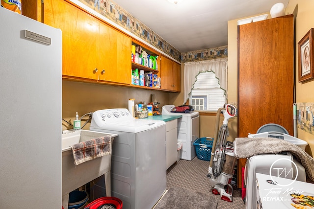 washroom with cabinets, sink, and washing machine and clothes dryer