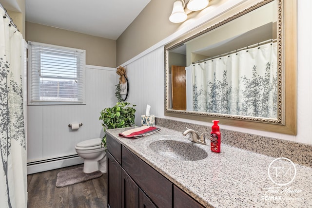 bathroom featuring vanity, wood-type flooring, a baseboard radiator, toilet, and wood walls