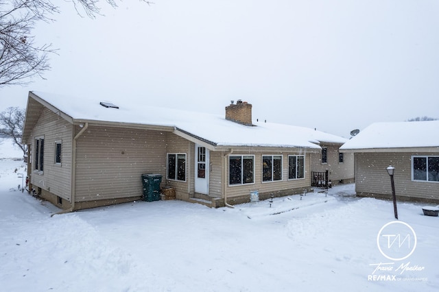 view of snow covered back of property