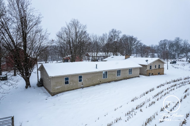 view of snow covered back of property