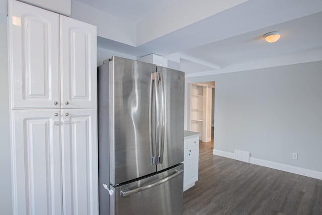 kitchen with stainless steel refrigerator, white cabinets, and dark wood-type flooring