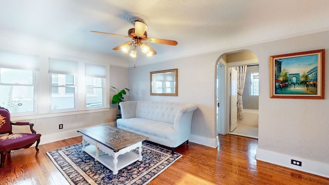 living room featuring a healthy amount of sunlight, ceiling fan, and wood-type flooring