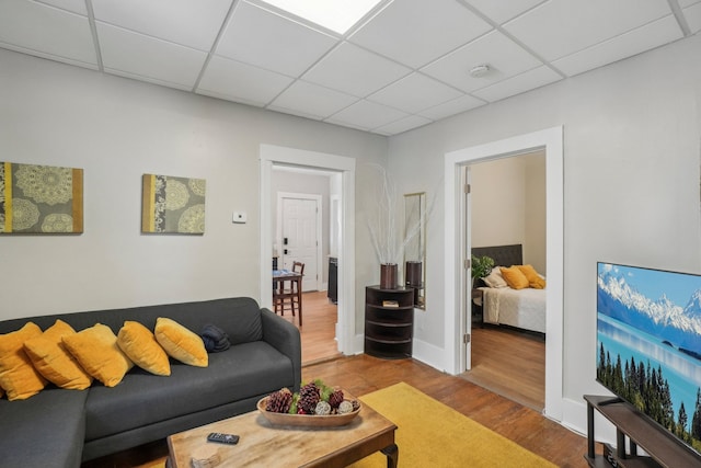 living room with a paneled ceiling and hardwood / wood-style floors