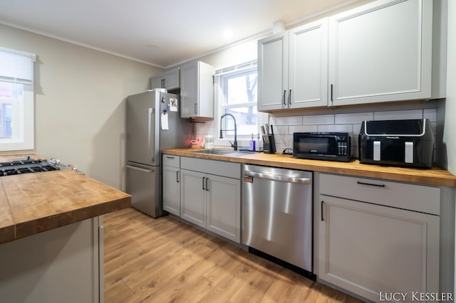 kitchen featuring wooden counters, sink, gray cabinetry, and stainless steel appliances