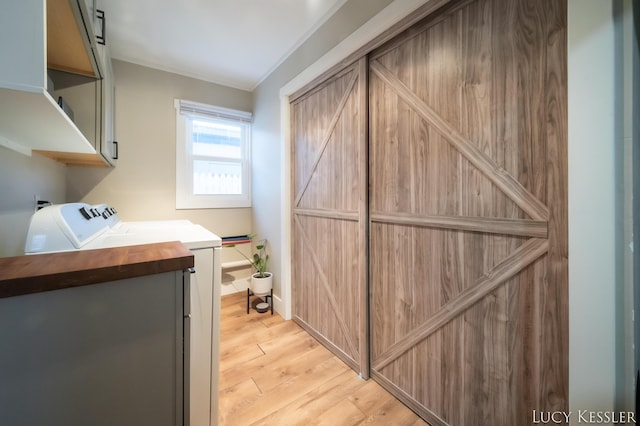 interior space with vanity, wood-type flooring, washing machine and clothes dryer, and ornamental molding