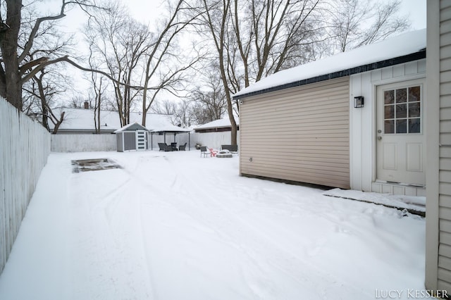 snowy yard featuring a shed