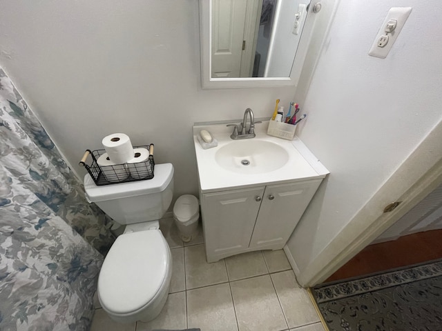 bathroom with tile patterned flooring, vanity, and toilet