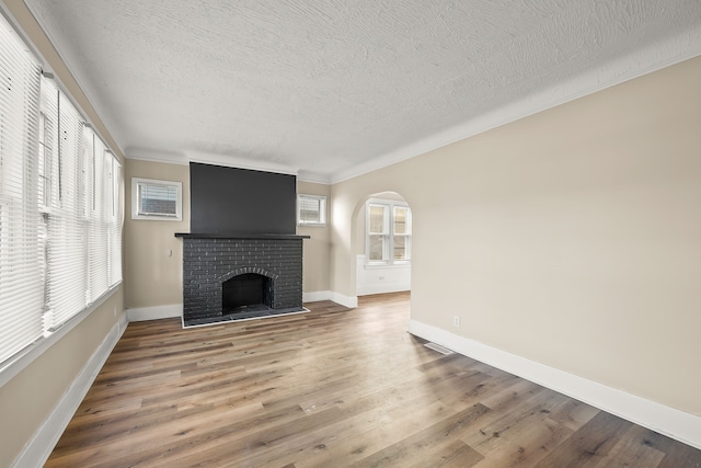 unfurnished living room with hardwood / wood-style flooring, a textured ceiling, and a fireplace