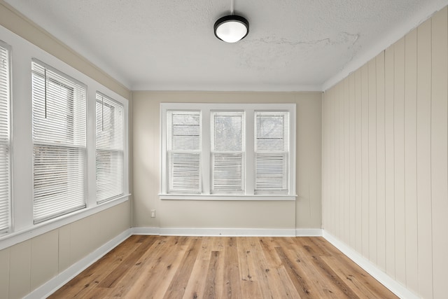 interior space featuring plenty of natural light, a textured ceiling, and light wood-type flooring