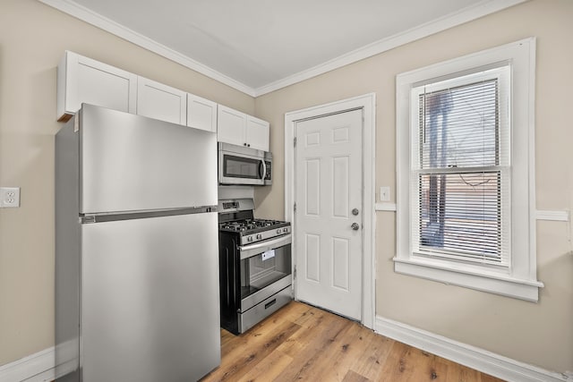 kitchen featuring white cabinetry, appliances with stainless steel finishes, ornamental molding, and light hardwood / wood-style floors