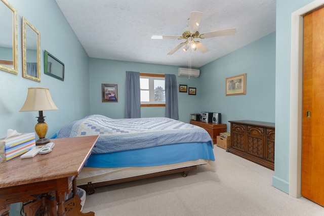 bedroom with ceiling fan, an AC wall unit, carpet floors, and a textured ceiling