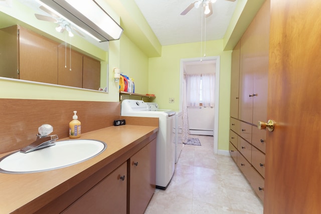 laundry room featuring washing machine and dryer, sink, ceiling fan, and a baseboard radiator