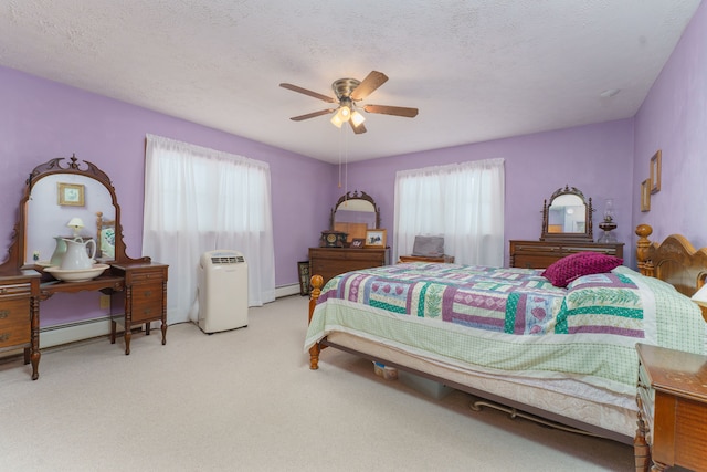 bedroom with multiple windows, light carpet, and a textured ceiling