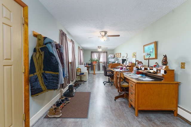 home office with wood-type flooring, a baseboard heating unit, ceiling fan, and a textured ceiling