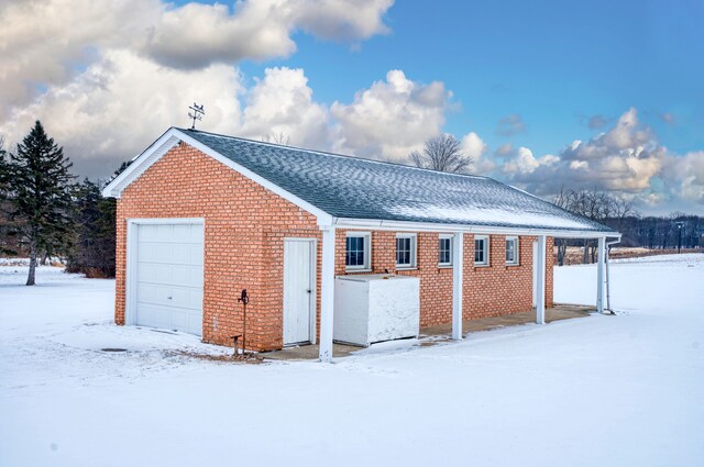 view of snowy exterior featuring a garage