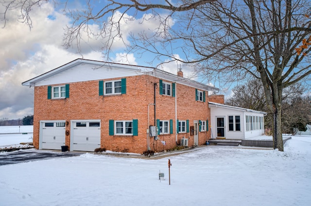 view of front of property featuring a garage and central AC unit