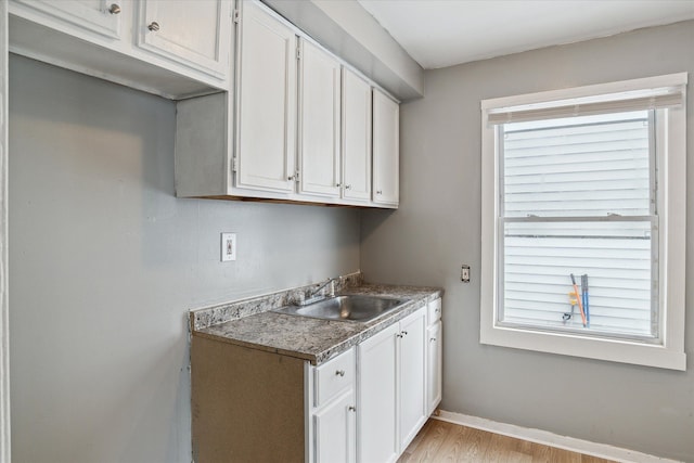 laundry room with light hardwood / wood-style flooring and sink