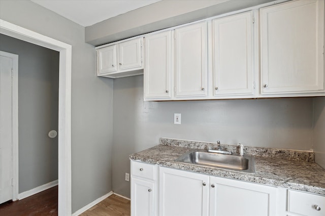 kitchen with white cabinetry, sink, and dark wood-type flooring