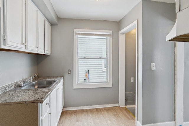 laundry room featuring light hardwood / wood-style floors and sink