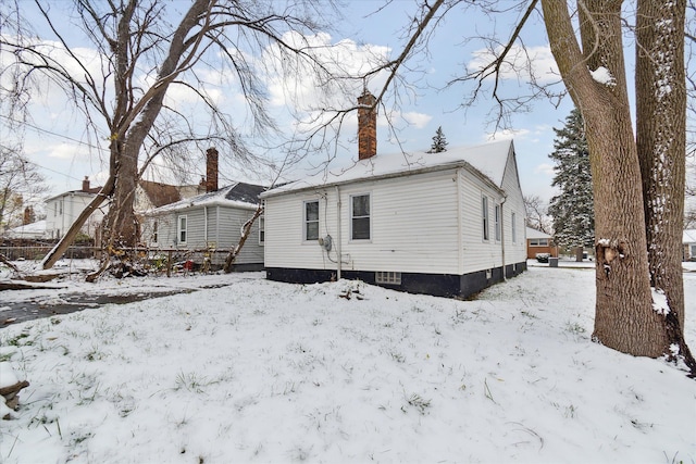 view of snow covered rear of property