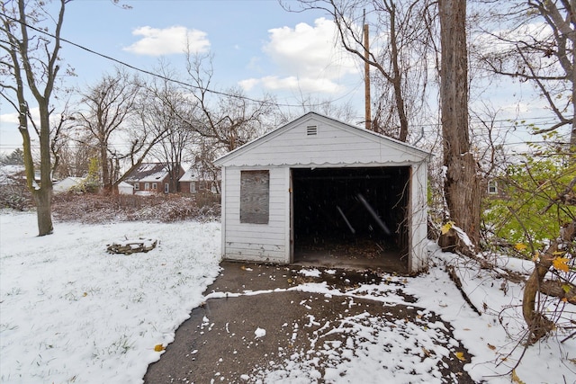 snow covered structure with a garage