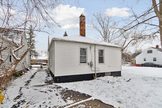 view of snow covered rear of property