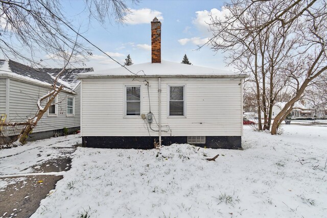 view of snow covered back of property