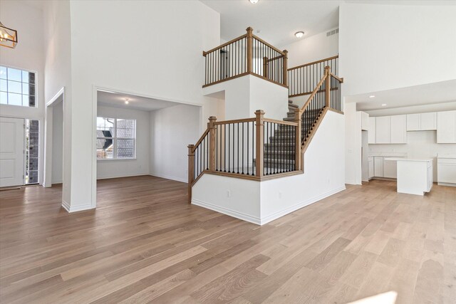 foyer entrance with light hardwood / wood-style flooring and a high ceiling