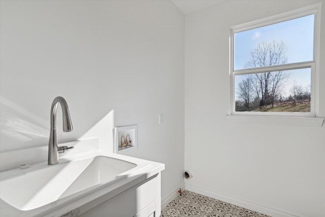 laundry room with cabinets, washer hookup, light tile patterned floors, and sink