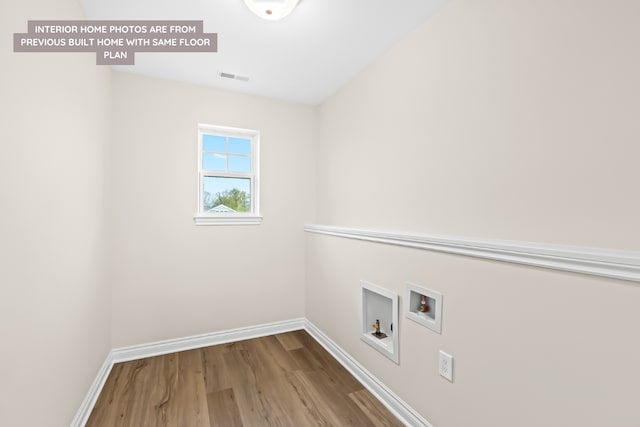 washroom with washer hookup, laundry area, baseboards, and wood finished floors